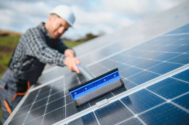 Solar panel service worker is cleaning a solar panel