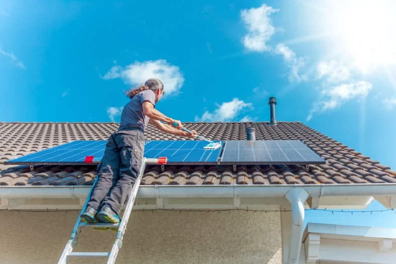 A man is mopping rooftop solar panels