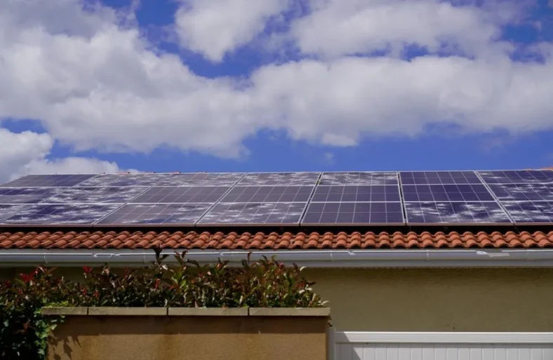 A residential roof with solar panels damaged by hail