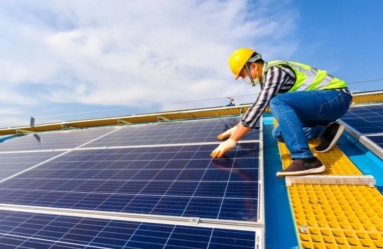 A worker installing solar photovoltaic panel system on the roof.