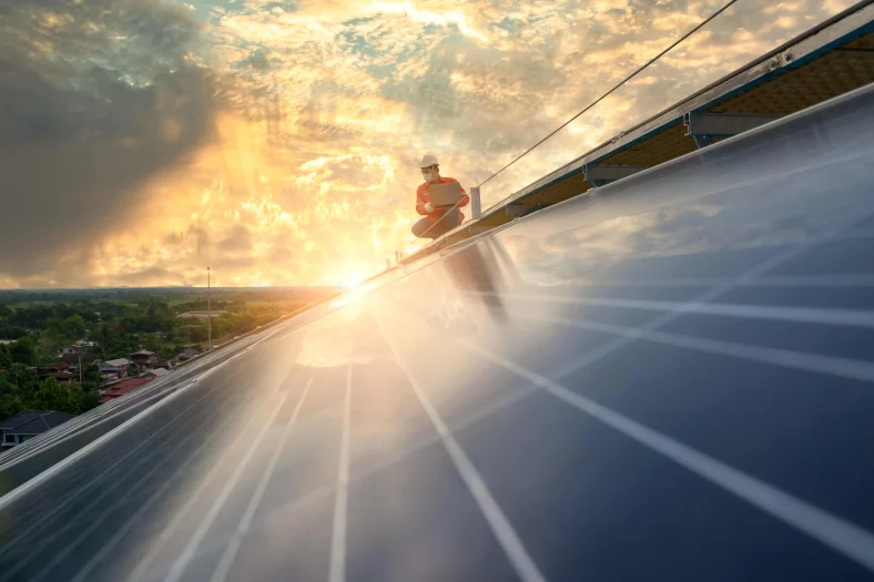 Engineer on the top of the roof checking the performance of a solar power system