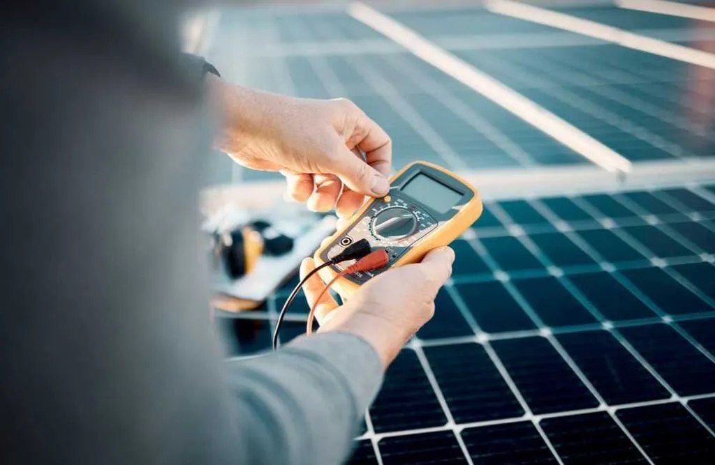 Solar panels, multimeter and engineering hands for voltage check, installation or maintenance.