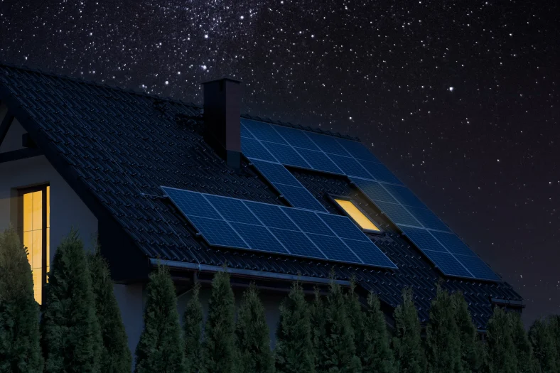 A house with solar panels on the roof under the night sky