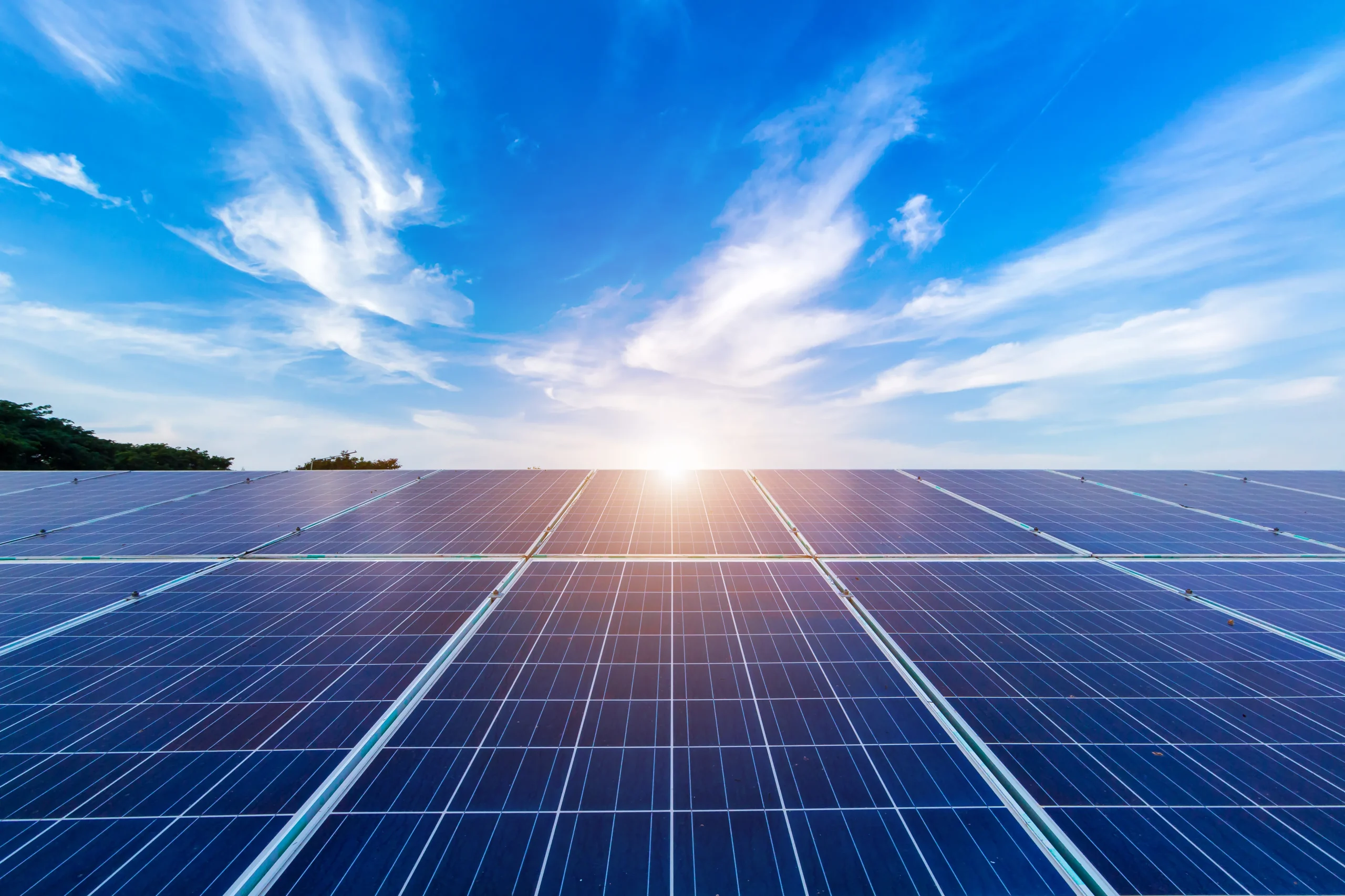 Solar panels lit with sun rays on blue sky background