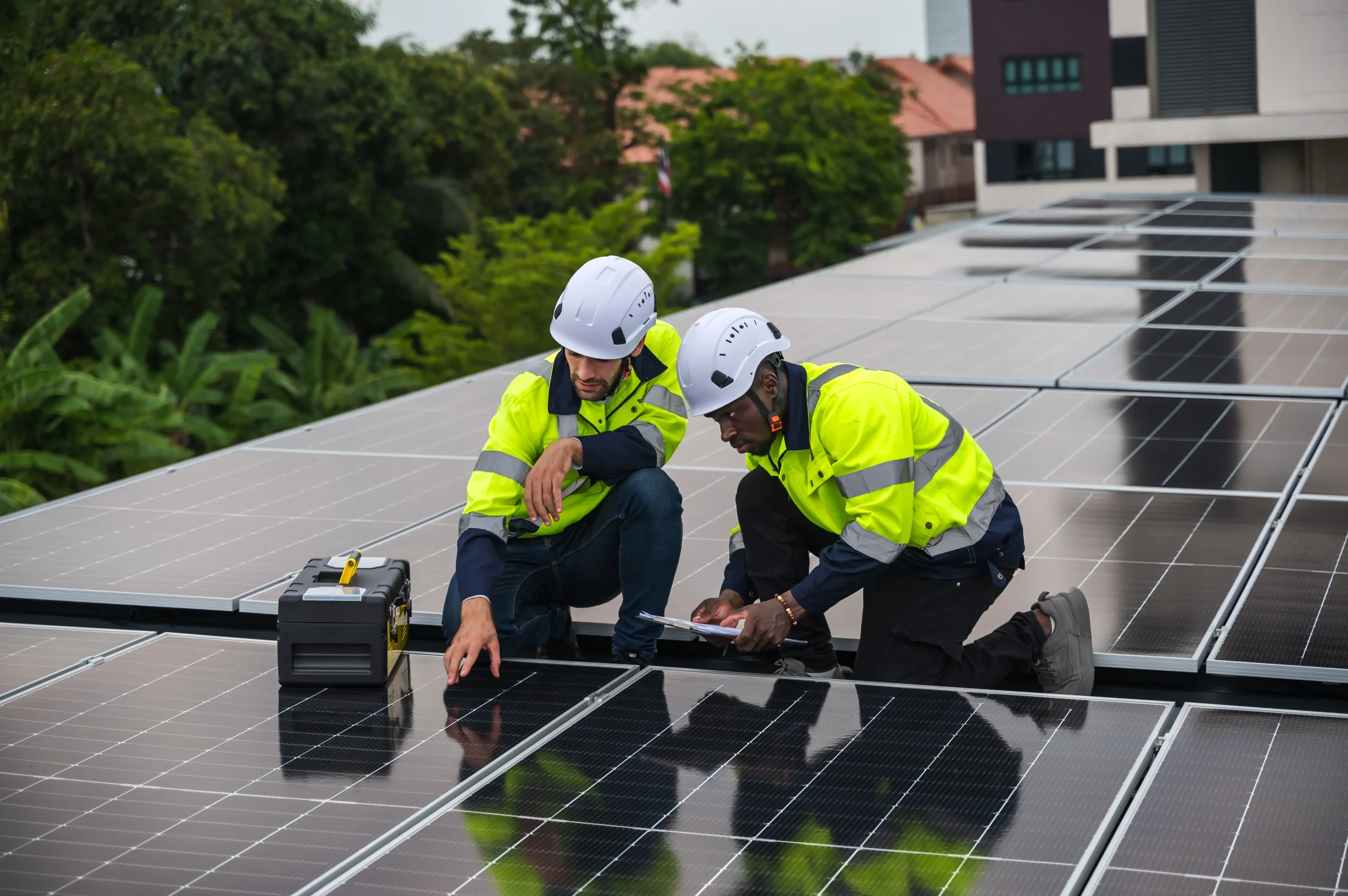 Two technicians checking solar panels installed on the rooftop