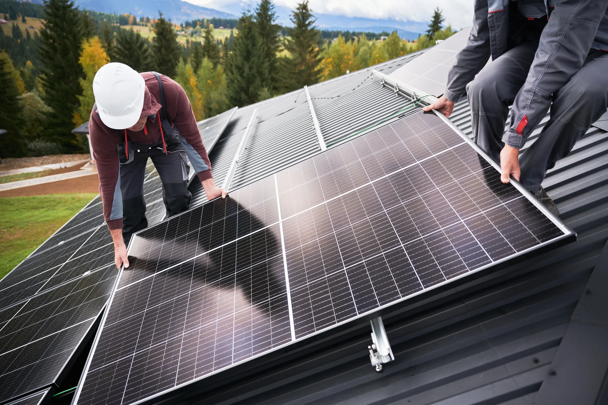 The team of solar installers mounting panels onto the roof