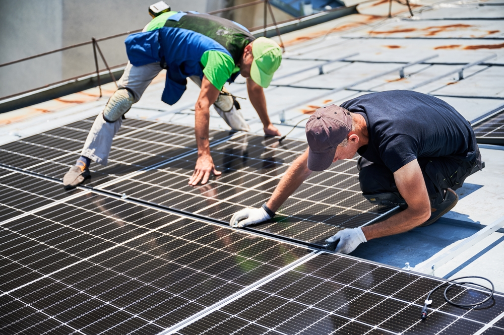 A couple of workers building a solar system and installing panels.