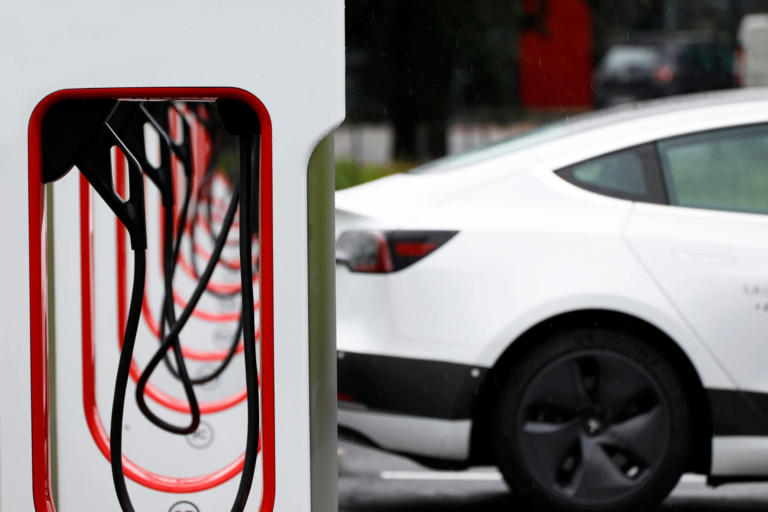 An electric car and Tesla superchargers at a charging station