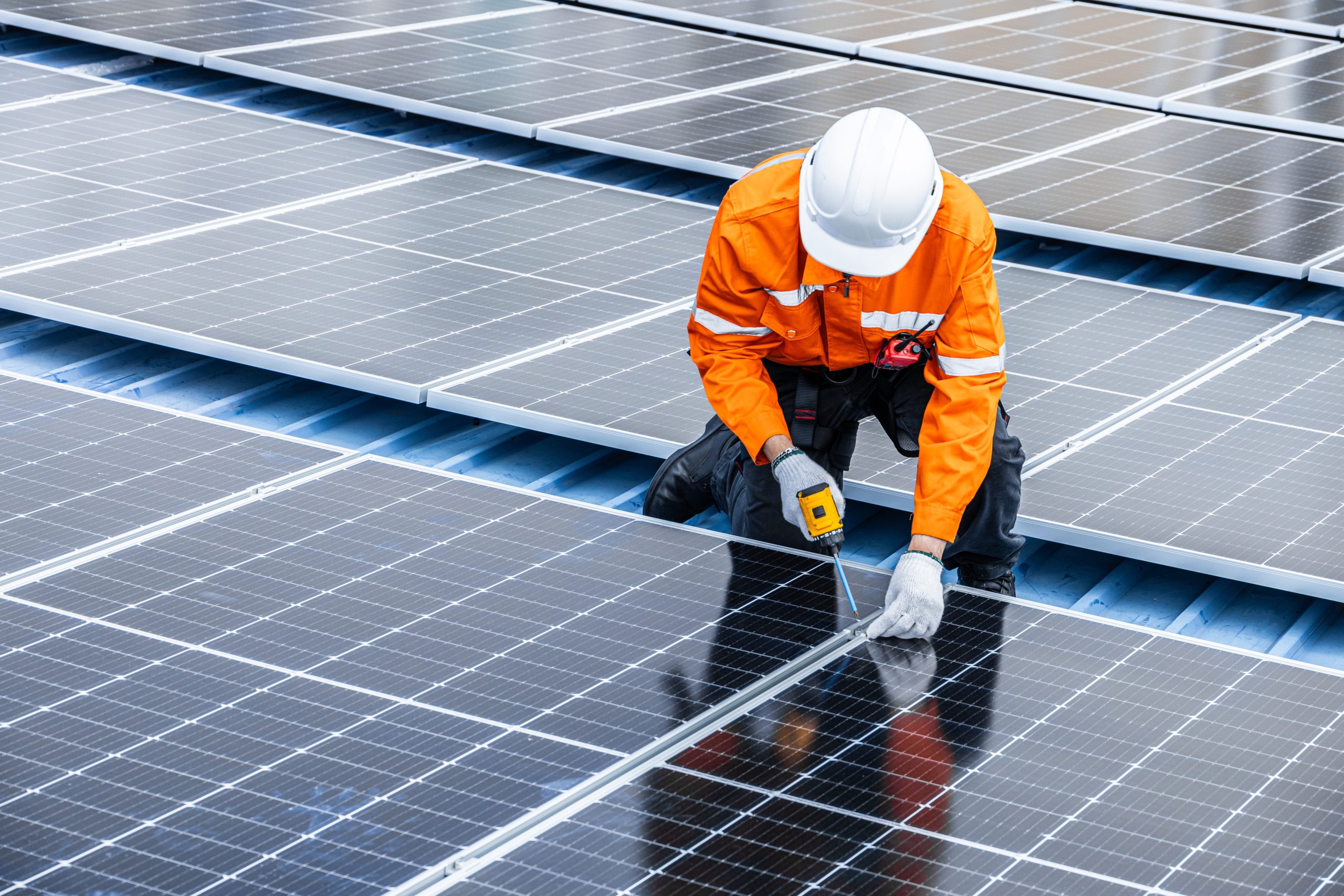An engineer installing solar panels on the roof of the building