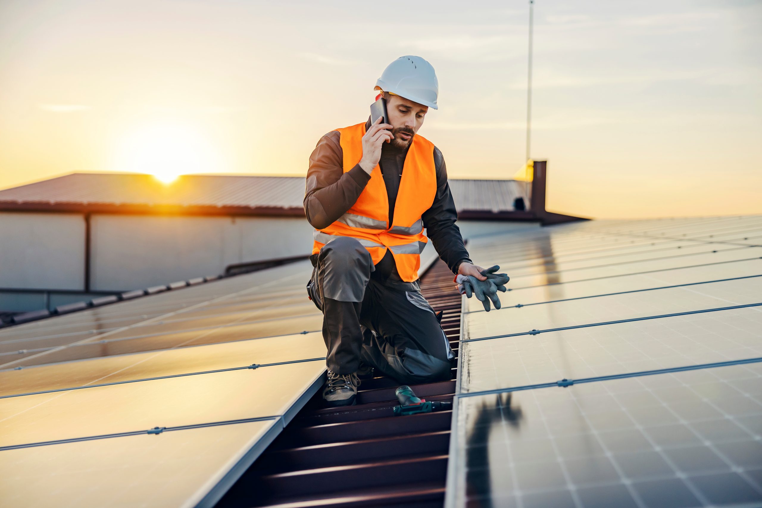 A handyman talking on the phone regarding the solar panel installation mistakes he encountered